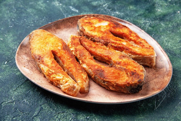 side-view-delicious-fried-fish-brown-plate-left-side-mix-colors-table-with-free-space