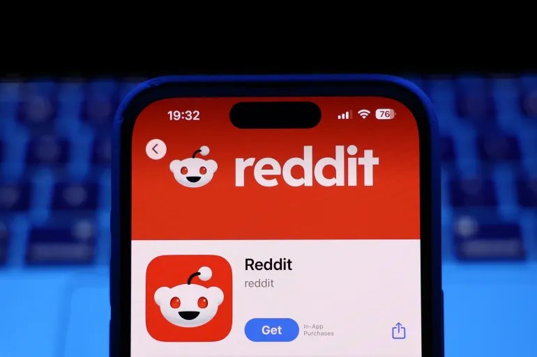 A laptop keyboard and Reddit on App Store