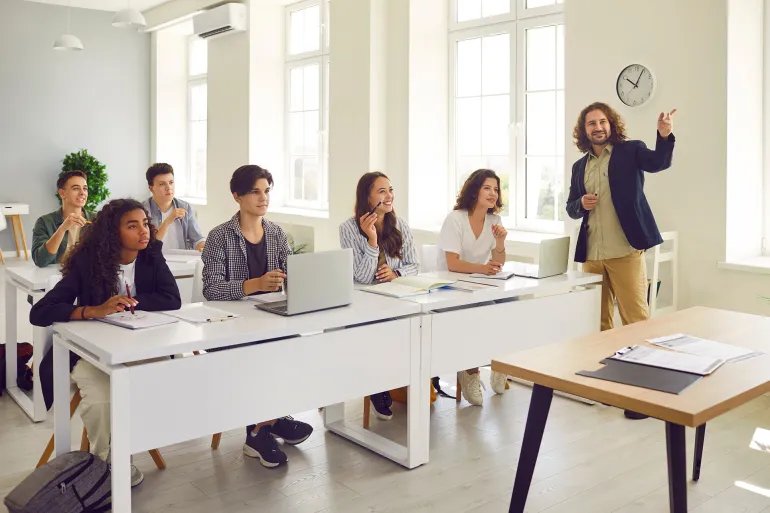 Male young friendly teacher at the lesson in high school
