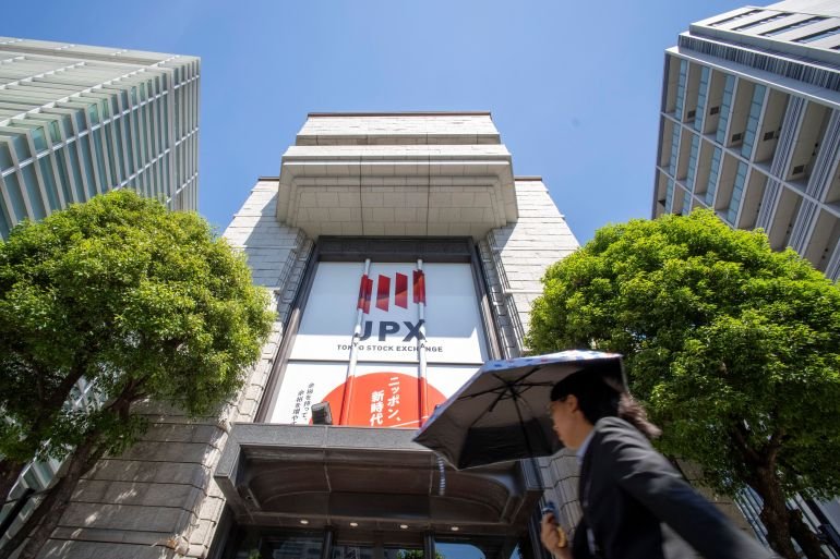 A woman walks in front of the Tokyo Stock Exchange in Tokyo